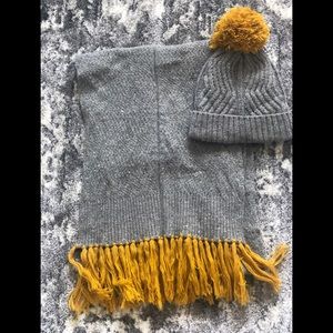 Matching winter hat and scarf.  Gray with mustard yellow pom pom and fringe.